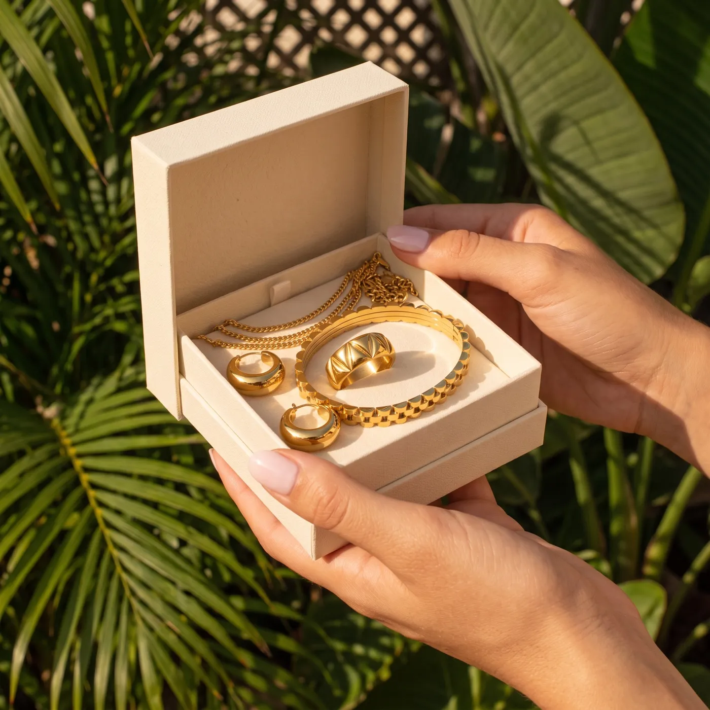 Handen die een sieradenbox met 7 gouden sieraden openen